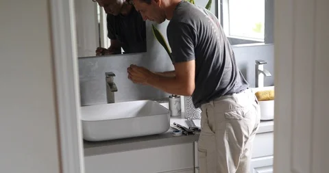 Plumber Working on Sink in Bathroom Stock Footage 120670613
