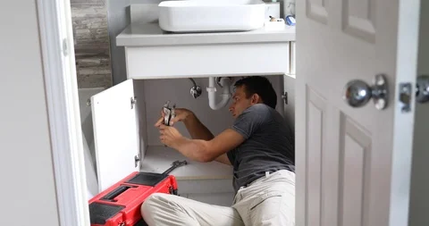 Plumber Working on Sink in Bathroom Stock Footage 120670633