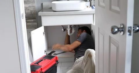 Plumber Working on Sink in Bathroom Stock Footage 120670637