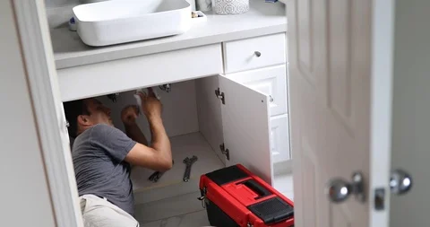 Plumber Working on Sink in Bathroom Stock Footage 120670643