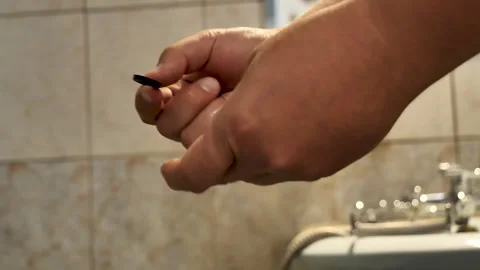 A plumber's hands do the work of installing a gasket in a faucet Stock Footage 259125777