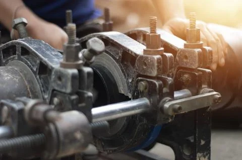 Plumbers use tools to connect large water pipes. Stock Photos