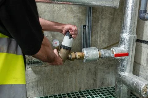 Plumbing commissioning engineer setting up a pressure reducing valve Foto stock