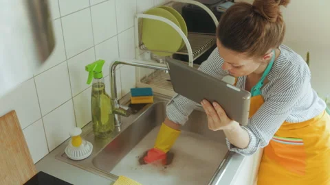 Plumbing Problem: Woman Using Tablet While Washing Dishes Stock Footage 312237291
