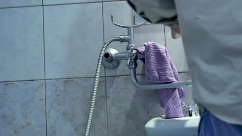 Plumbing technician performs repair work to replace bathroom faucet Stock Footage 259129215
