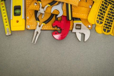Plumbing tools in the bag and work gloves on gray desktop are used to replace Foto stock