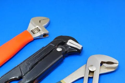 Plumbing work tools on a blue background. Stock Photos