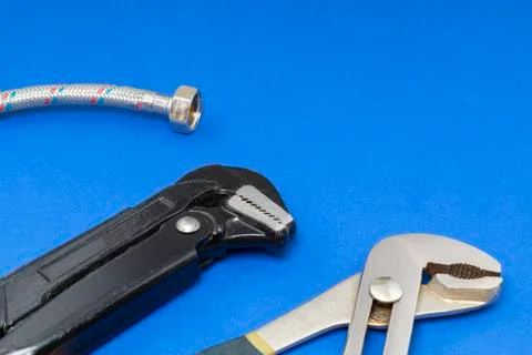 Plumbing work tools on a blue background. Stock Photos