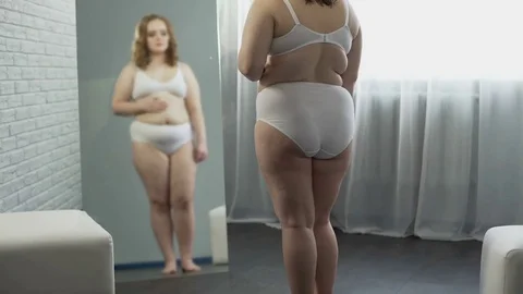 Plump girl with excess weight checking skin, looking for cellulite on body Video stock 74938954