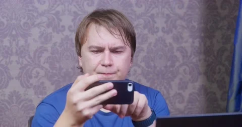 Plump man gets scared looking at screen of mobile phone Stock Footage 167244170