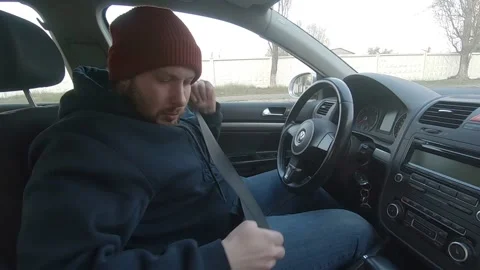 A plump man in a hat who looks like a car thief is fastened on. Video stock 144353036