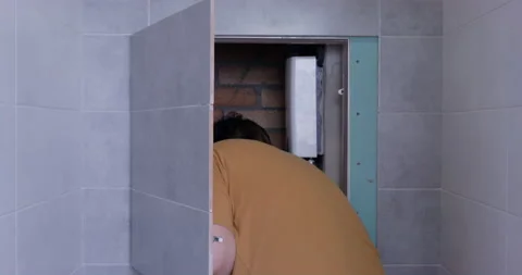 Plump man opens secret place behind tile in bathroom Stock Footage 178204907