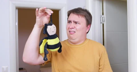 Plump man picks up plush toy slobbered by dogs feeling sick 스톡 동영상 201762735