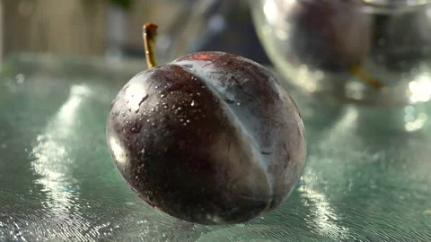Plums bouncing on glass surface Stock Footage 138894976