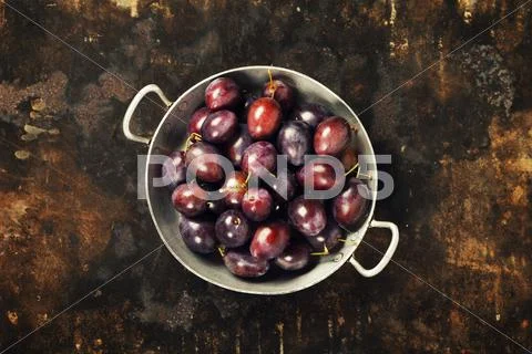 Plums in a bowl on a rural background Stock Photos