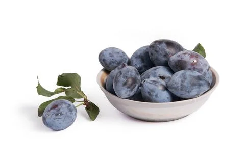 Plums in a plate on a white background Stock Photos