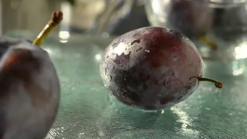 Plums Plums bouncing on glass cutting board Stock Footage 138895022