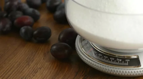 Plums rolling around a kitchen scale with sugar. 스톡 동영상 12246444