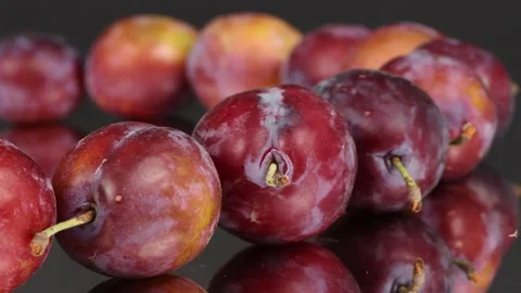 Plums in a row on mirror. Rotation with acceleration. Side view. Stock Footage 161319158