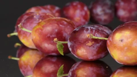 Plums in a row on mirror. Rotation with acceleration. Side view. Stock Footage 161319693