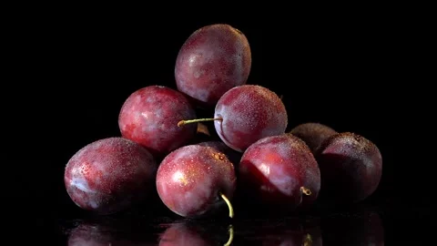 Plums with water drops on black background Stock Footage 163517080