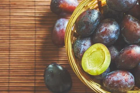Plums in weaved basket Stock Photos