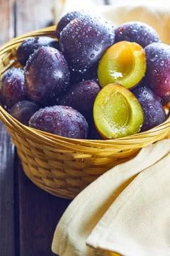 Plums in weaved basket Stock Photos