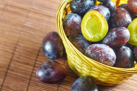Plums in weaved basket Stock Photos