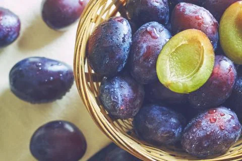Plums in weaved basket Stock Photos