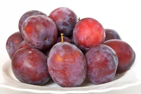 Plums on a white plate Stock Photos