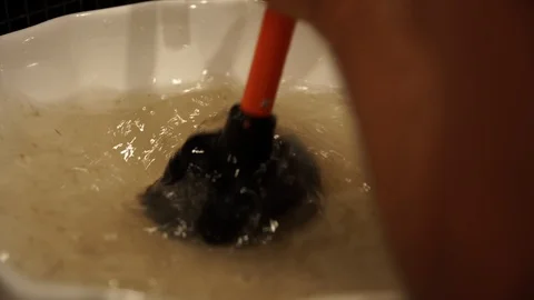 Plunger trying to remove clogged sinks Stock Footage 103121402