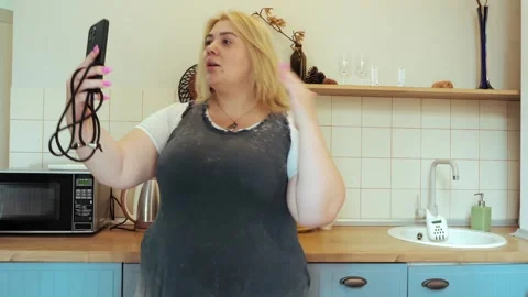 Plus-size female influencer streams kitchen video for social media followers Stock Footage 280141512