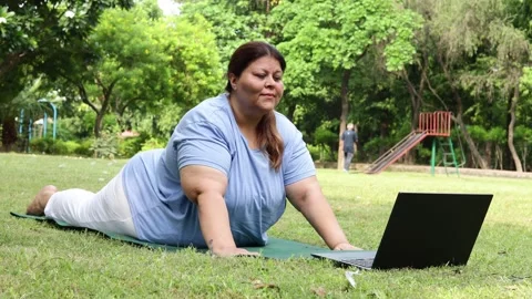 Plus size indian woman do virtual yoga class on computer laptop while exerc.. Stock Footage 316660552