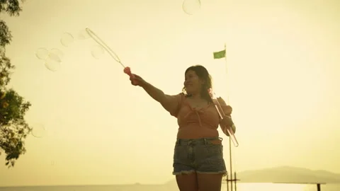 Plus size ladies having fun playing bubbles in the evening Stock Footage 223381498