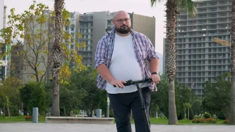 Plus size man riding e-scooter in the city. Male driving electric scooter Stock Footage 270586914