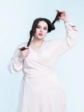 Plus Size Model plays with her long hair posing in studio Stock Photos