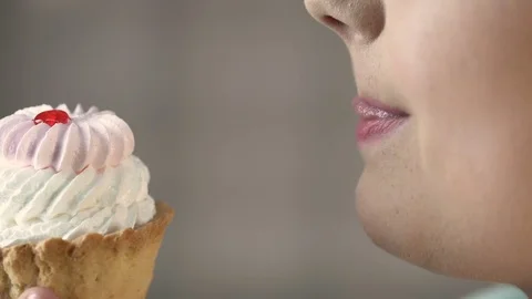 Plus size woman biting piece of cake, overweight and unhealthy food, diabetes Stock Footage
