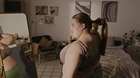 Plus Size Woman Looking in Mirror and Smiling with Body Positivity Stock Footage 337908232