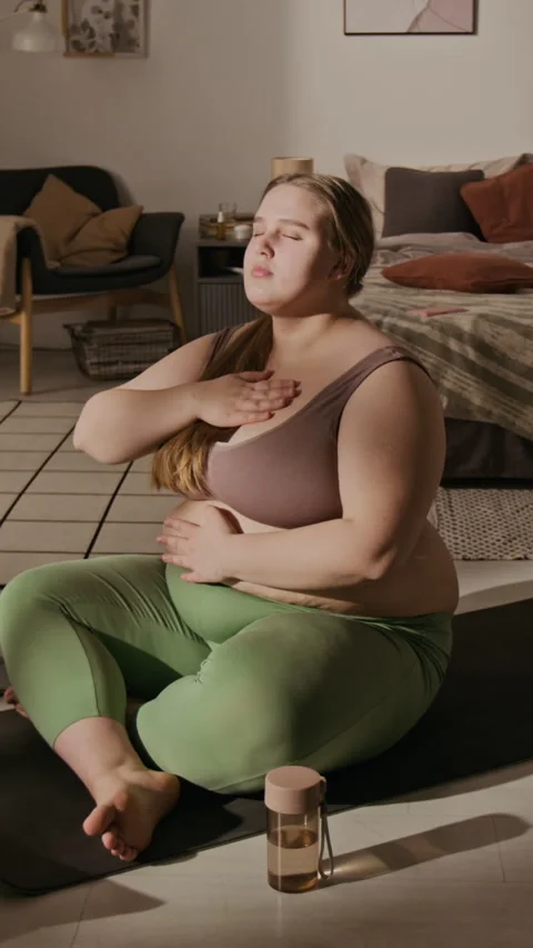 Plus-size Woman Practicing Mindfulness Breathing Exercise at Home Stock Footage 337910475