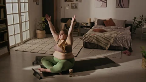 Plus Size Woman Practicing Yoga with Online Tutorial at Home Stock Footage 337907340