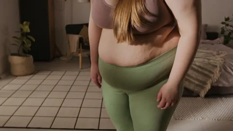 Plus Size Woman Stepping on Scale and Smiling with Body Positivity Stock Footage 337908310