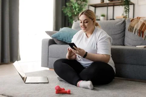 Plus size woman using gadgets for sport Stock Photos