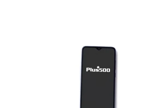 Plus500 app launch screen with logo on the display of a black mobile smartpho Stock Photos