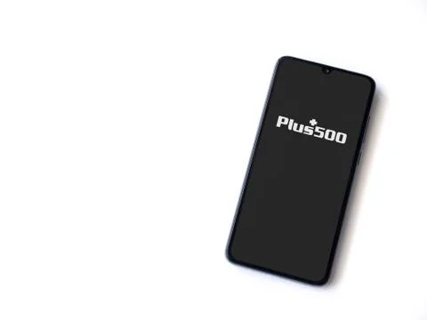 Plus500 app launch screen with logo on the display of a black mobile smartpho Stock Photos