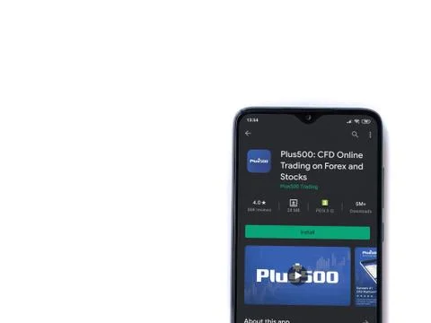 Plus500 app play store page on the display of a black mobile smartphone isola Stock Photos
