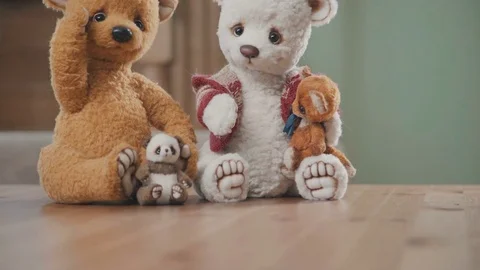 Plush bears handmade: two large teddy bears and two small on the table Stock Footage