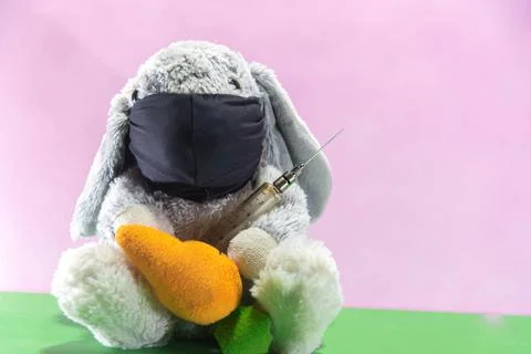 Plush Easter rabbit using mask and syringe to fight the covid-19 写真素材