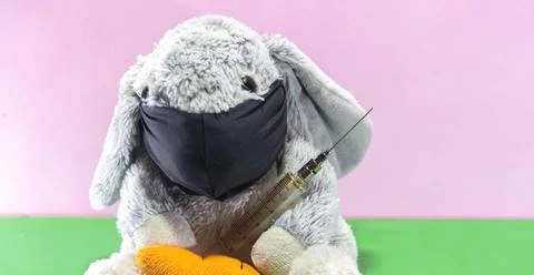 Plush Easter rabbit using mask and syringe to fight the covid-19 Stockfoto's