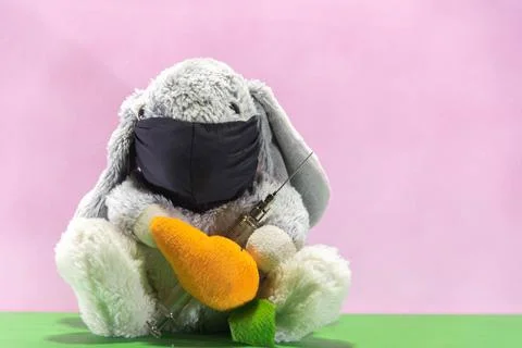 Plush Easter rabbit using mask and syringe to fight the covid-19 Stockfoto's