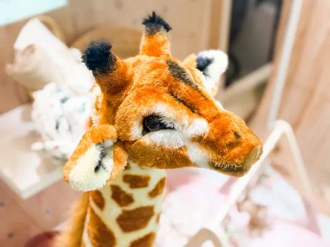 Plush giraffe toy with spotted pattern in store. Childhood fantasy, comfort.. Stock Photos
